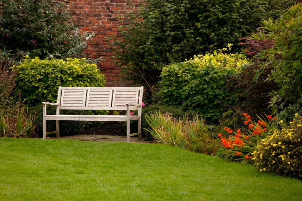 A garden retreat with a brick retaining wall in the background. 