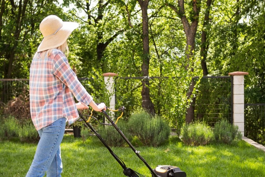 A woman mowing grass.