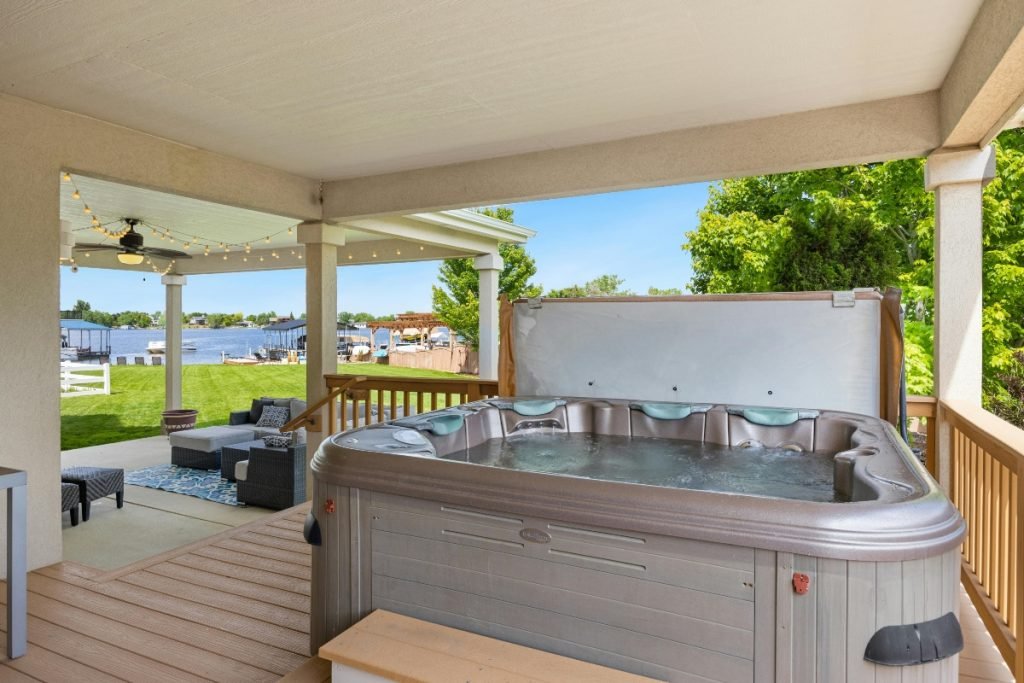 A multi-level deck with a hot tub and a lounge area.