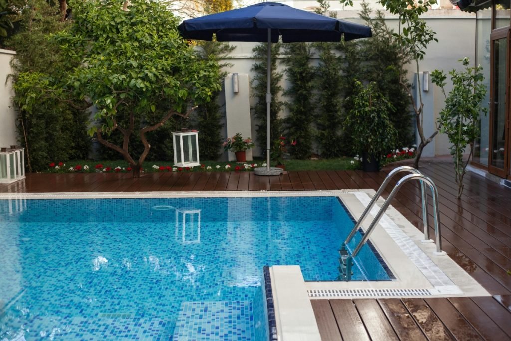 A pool-side deck with integrated greenery for added privacy.