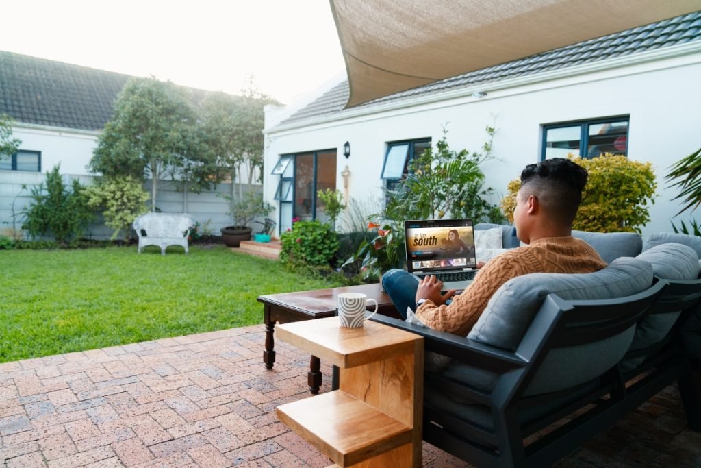 A man watching a show on his backyard patio.
