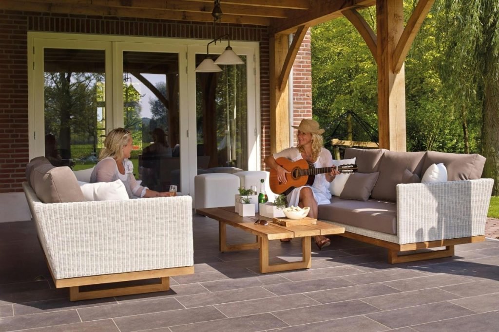 Women relaxing on a concrete patio at home.