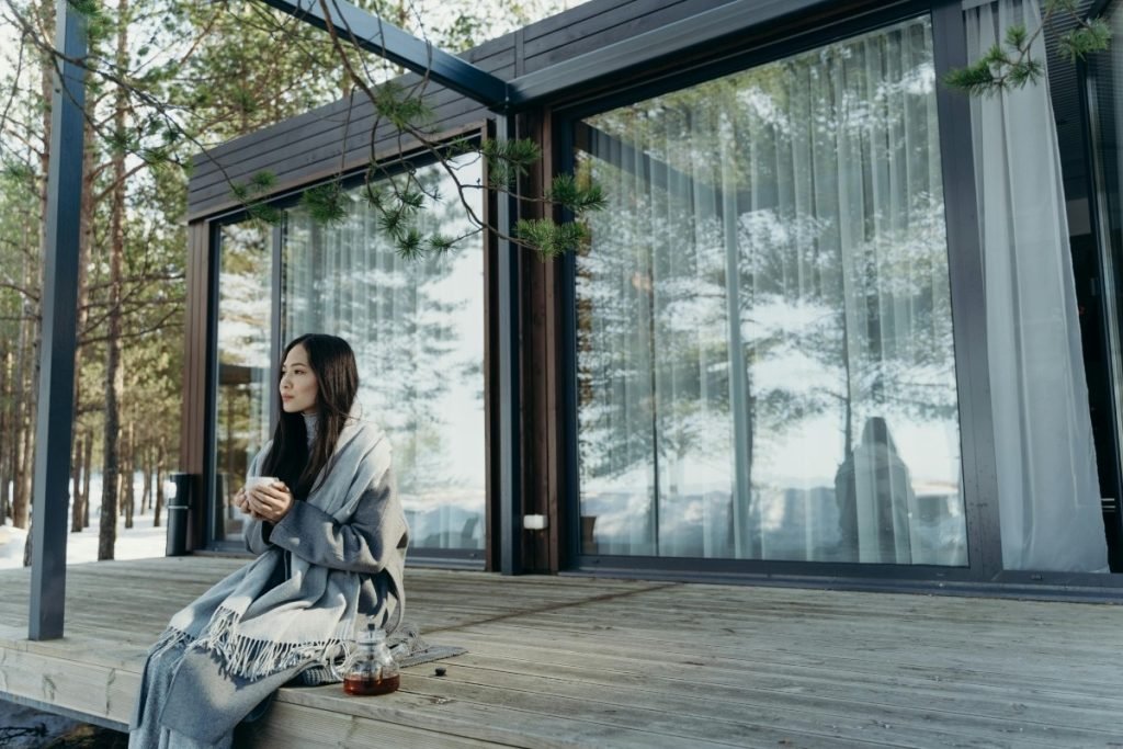 A woman sitting on a wooden deck.