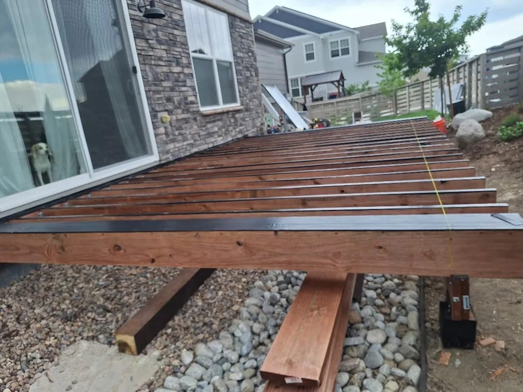 Deck frame attached to the house with joists and beams for a Deckorators composite deck near Highlands Ranch