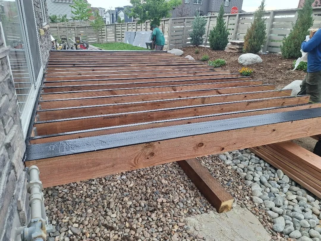 Deckorators deck framing with joist tape on a Sterling Ranch home, built by Elevate Landscape & Spas