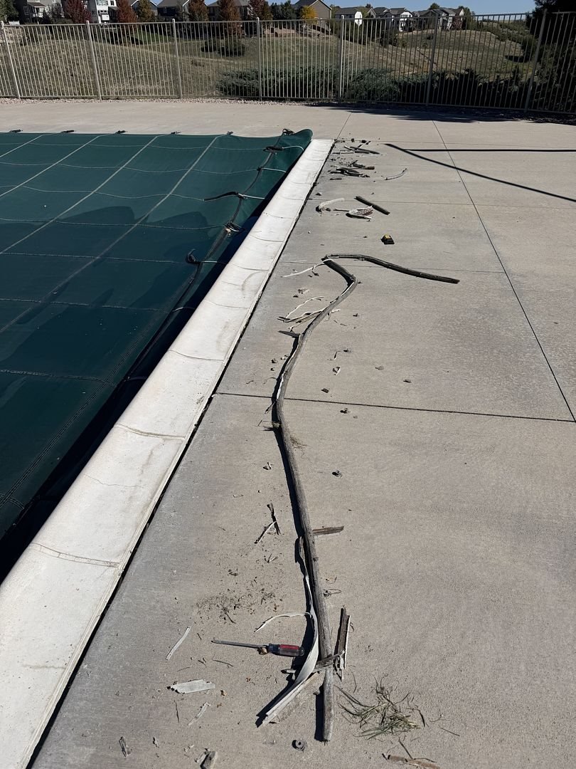 Failed pool expansion joint with old mastic pulling out of the gap between coping and deck