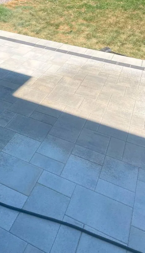 Paver patio being lightly wetted to set the polymeric sand in the joints